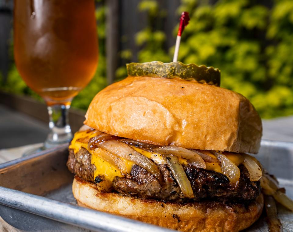 The Burger, a half-pound Wisconsin beef patty with two slices of American cheese and grilled onions on a brioche bun, is paired with a Bell's Two Hearted Ale at Camino in Milwaukee's Walker's Point neighborhood.