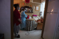 Nurse Pilar Rodríguez speaks with her patient Antonia Crespi Gomila after administering the vaccine against COVID-19 at her home in the town of Sa Pobla on the Spanish Balearic Island of Mallorca, Spain, Friday, April 30, 2021. (AP Photo/Francisco Ubilla)