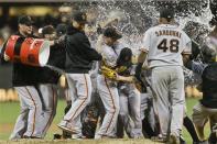 The water bath hits the San Francisco Giants as they celebrate the no hitter thrown by Giants pitcher Tim Lincecum against the San Diego Padres in a baseball game in San Diego, Saturday, July 13, 2013. The Giants won the game 9-0. Tim Lincecum has thrown his first career no-hitter and the second in the majors in 11 days, a gem saved by a spectacular diving catch by right fielder Hunter Pence in the San Francisco Giants' 9-0 win against the last-place San Diego Padres on Saturday night. (AP Photo/Lenny Ignelzi)