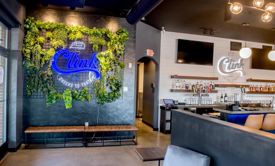 A bright sign and decorated backdrop create a photo opp for customers of the new Clink Bar and Events in Peoria Heights' Heritage Square.