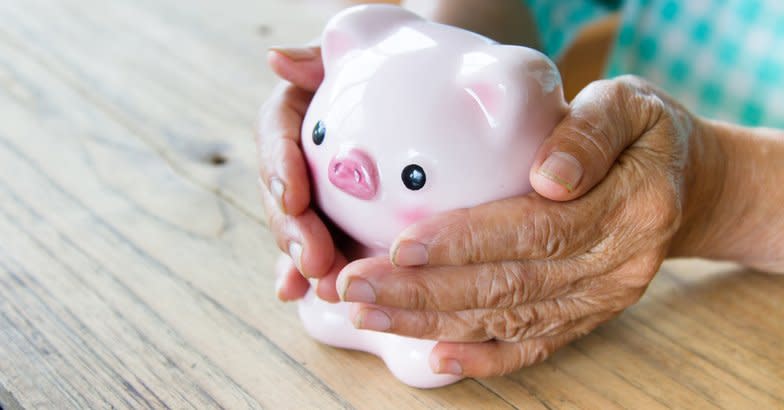 Senior woman's hands holding a piggy bank