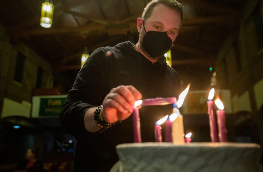 Burbank, CA - March 01: Pastor Ryan Chaddick lights a candle during a vigil at American Lutheran Church on Wednesday, March 1, 2023, in Burbank, CA. People gather at American Lutheran Church in Burbank for a vigil marking Disability Day of Mourning, which memorializes disabled people murdered by family members or caregivers. (Francine Orr / Los Angeles Times)