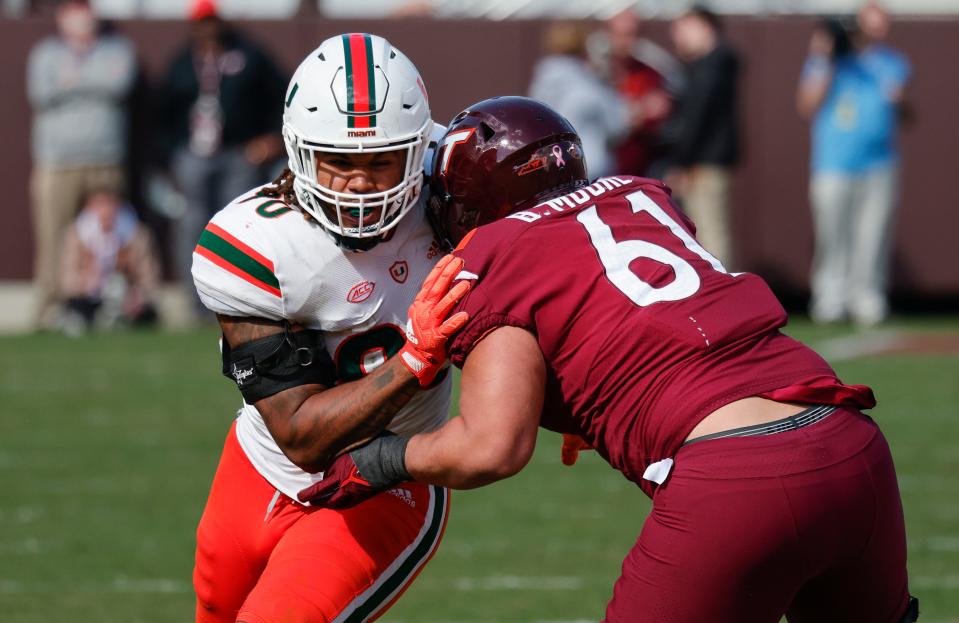 Oct 15, 2022; Blacksburg, Virginia, USA;  Virginia Tech Hokies offensive lineman Braelin Moore (61) blocks Miami Hurricanes defensive lineman Akheem Mesidor (90) during the second half at Lane Stadium. Mandatory Credit: Reinhold Matay-USA TODAY Sports