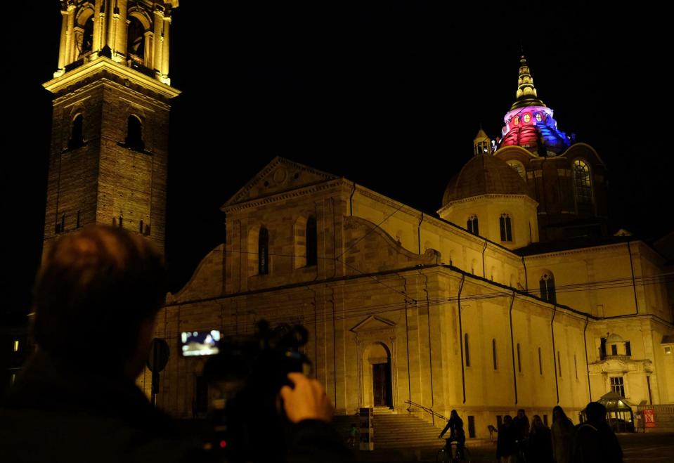 The dome of the Chapel of the Shroud is illuminated with the colors of the French flag in Turin, Italy, Tuesday, April 16, 2019. The Archbishop of Turin says that the Notre Dame fire brought back painful memories of the 1997 blaze that tore through the chapel that is home to the Shroud of Turin. Monsignor Cesara Nosiglia on Tuesday recalled the dramatic events of April 11, 1997 when firemen rescued the shroud, venerated as the holy cloth in which Jesus was wrapped after his crucifixion, from its bulletproof, climate-controlled glass case.(Alessandro Di Marco/ANSA via AP)