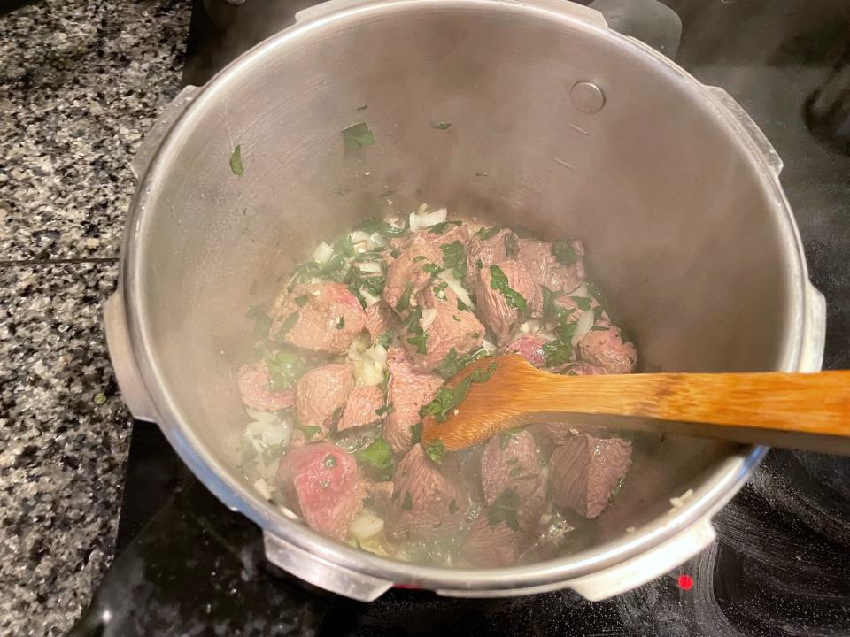 Adding onions and parsley to meat for Greek dad's kritharaki