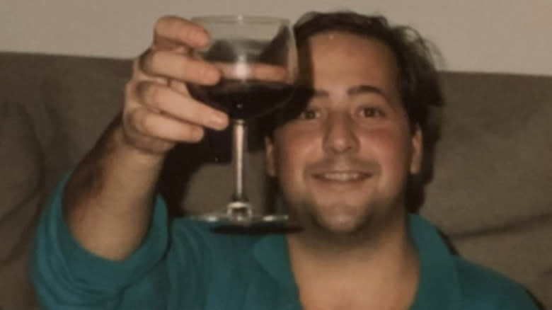 Young Andrew Zimmern raises wine glass