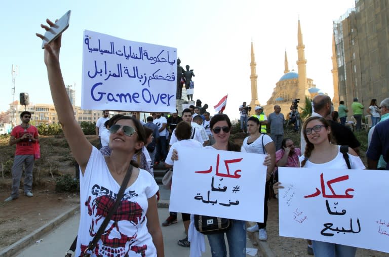 Lebanese women hold signs before the start of an anti-government protest on August 29, 2015 at Beirut's iconic Martyrs Square