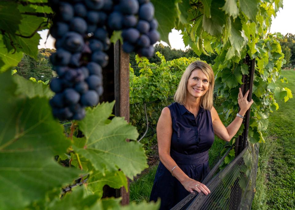 Black Star Farms proprietor Sherri Campbell Fenton stands in a field of grapes at her winery, B&B and gourmet restaurant in Suttons Bay on Sept. 16, 2021.