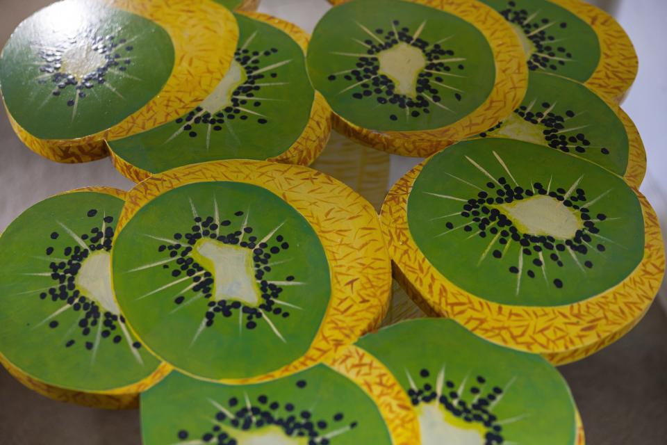 Close-up of a table, painted with half-opened kiwis.