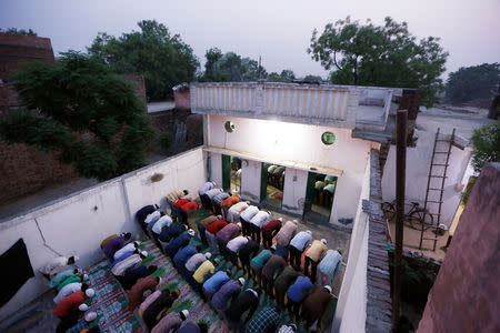 FILE PHOTO: Muslims offer prayer after eating their Iftar (breaking of fast) meal during the holy month of Ramadan inside a madrasa that also acts as a mosque in village Nayabans in the northern state of Uttar Pradesh, India May 9, 2019. REUTERS/Adnan Abidi