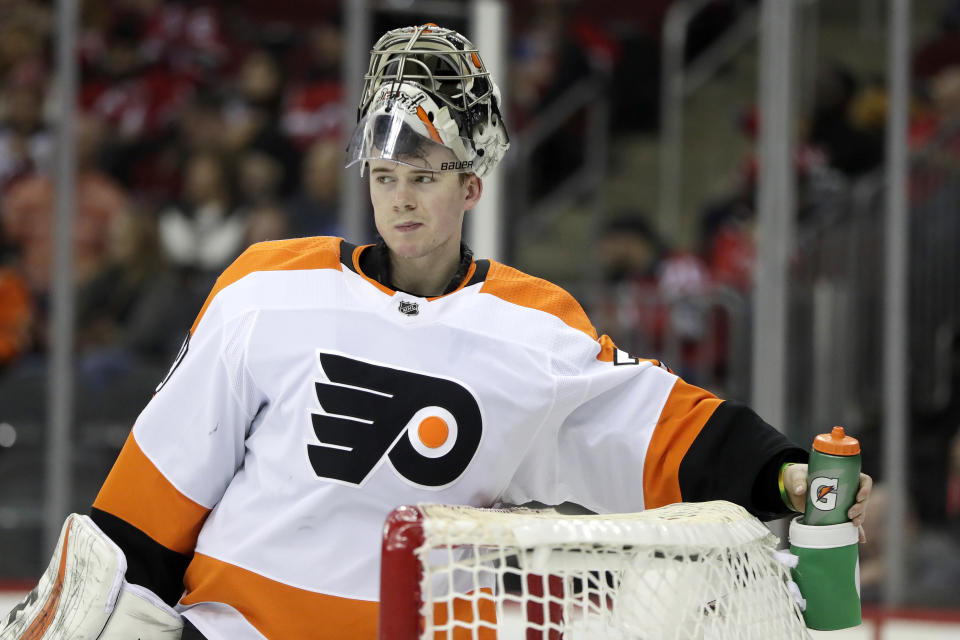 Philadelphia Flyers goaltender Carter Hart grabs his water bottle between plays against the New Jersey Devils during the second period of an NHL hockey game, Saturday, Jan. 12, 2019, in Newark, N.J. (AP Photo/Julio Cortez)