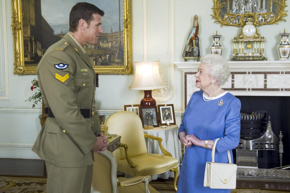 FILE - Britain's Queen Elizabeth II greets Corp. Ben Robert-Smith, from Australia, who was recently awarded the Victoria Cross, during an audience at Buckingham Palace in London, on Nov. 15, 2011. A judge concluded Roberts-Smith unlawfully killed prisoners and committed other war crimes in Afghanistan, in a ruling Thursday, June 1, 2023 dismissing Roberts-Smith's claims that he was defamed by media reports about his war service. (AP Photo/Anthony Devlin, Pool, File)
