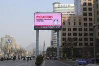 In this Thursday, Feb. 20, 2020, photo, a huge electric screen about precautions against the COVID-19 illness is seen in Seoul, South Korea. Even as cases and deaths from the new virus mount, fear is advancing like a tsunami - and not just in the areas surrounding the Chinese city of Wuhan, the center of the outbreak that has been declared a global health emergency. (AP Photo/Ahn Young-joon)