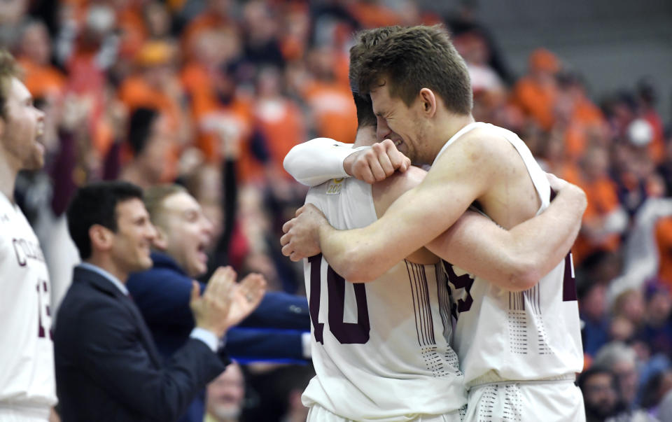 Colgate forward Rapolas Ivanauskas, right, hugs forward Will Rayman in the closing seconds of the team's NCAA college basketball game against Bucknell for the championship of the Patriot League men's tournament in Hamilton, N.Y., Wednesday, March 13, 2019. Colgate won 94-80. (AP Photo/Adrian Kraus)