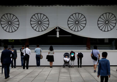 Visitors bow while paying tribute to the war dead at Yasukuni Shrine in Tokyo, Japan August 15, 2017, on the 72nd anniversary of Japan's surrender in World War Two. REUTERS/Issei Kato