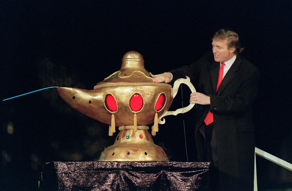 Real estate developer Donald J. Trump rubs a "magic lamp" during the opening ceremony for his huge Taj Mahal casino, in Atlantic city, 05 April 1990.  Billionaire Donald Trump, who was born in 1946, Queens, New York, has gained notability for his celebrity lifestyle and his real estate successes. / AFP PHOTO / BILL SWERSEY        (Photo credit should read BILL SWERSEY/AFP/Getty Images)