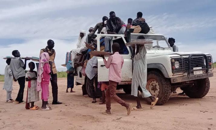 <span>Fleeing people take a break while travelling on the road from El Fasher to Tawila.</span><span>Photograph: Zeinab Mohammed Salih</span>