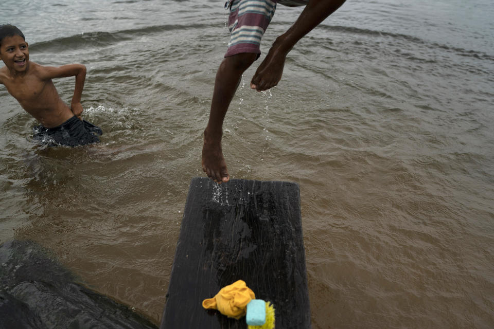 In this Nov. 21, 2019 photo, 10-year-old Kevin performs a somersault in the Uruara river as his friend looks on, at the entrance of the Renascer conservative unit of the Amazon rainforest in Prainha, Para state, Brazil. The clock is ticking. Already the Amazon is growing warmer and drier, losing its capacity to recycle water, and may become savannah in 15 to 30 years, said Carlos Nobre, a climate scientist at the University of Sao Paulo. (AP Photo/Leo Correa)