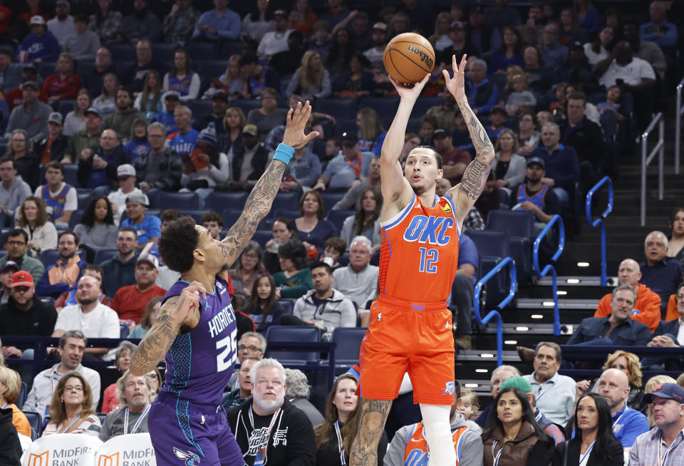 Feb 2, 2024; Oklahoma City, Oklahoma, USA; Oklahoma City Thunder forward Lindy Waters III (12) shoots a three point basket as Charlotte Hornets forward P.J. Washington (25) defends during the second quarter at Paycom Center. Mandatory Credit: Alonzo Adams-USA TODAY Sports