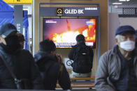 People watch a TV screen showing a file image of North Korea's missile launch during a news program at the Seoul Railway Station in Seoul, South Korea, Sunday, March 29, 2020. North Korea on Sunday fired two suspected ballistic missiles into the sea, South Korea said, calling it "very inappropriate" at a time when the world is battling the coronavirus pandemic.(AP Photo/Ahn Young-joon)