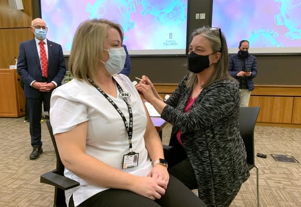 Newfoundland and Labrador's chief medical officer of health Dr. Janice Fitzgerald smiles at St. John's public health nurse Ellen Foley-Vick after giving her the Pfizer-BioNTech COVID-19 vaccine in St. John's, Nfld., on Wednesday, Dec. 16, 2020.