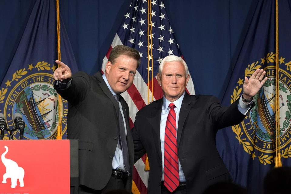 Former Vice President Mike Pence, right, waves as N.H. Gov. Chris Sununu introduces him at the annual Hillsborough County NH GOP Lincoln-Reagan Dinner, Thursday, June 3, 2021, in Manchester, N.H. (AP Photo/Elise Amendola)