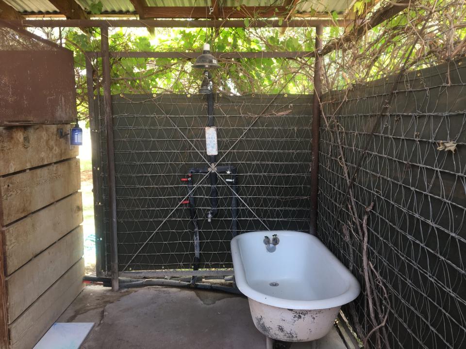 An outdoor bathroom with a bathtub.