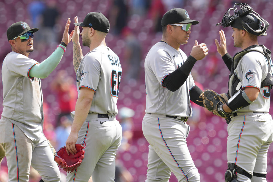 Miami Marlins shortstop Miguel Rojas, left, relief pitcher Tanner Scott (66), right fielder Avisail Garcia, center right, and catcher Nick Fortes celebrate after defeating the Cincinnati Reds in a baseball game Thursday, July 28, 2022, in Cincinnati. (AP Photo/Jeff Dean)