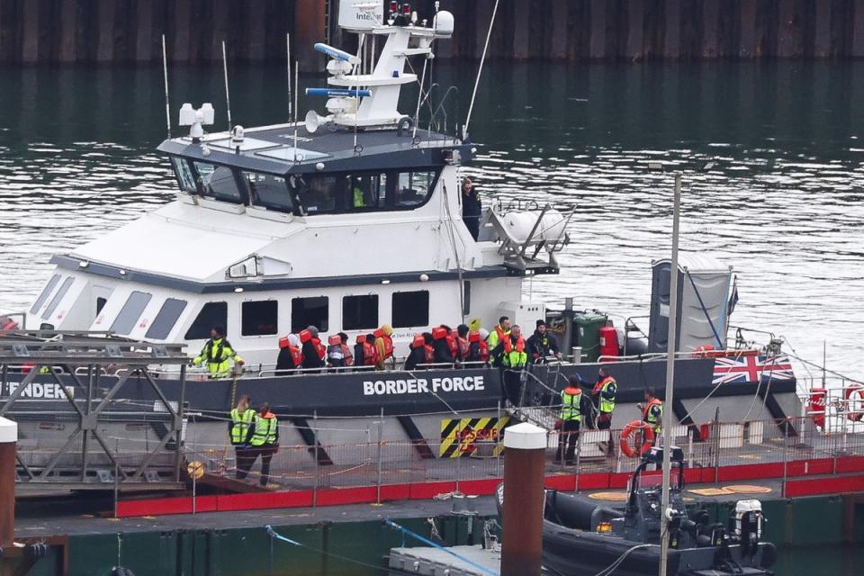 People, believed to be migrants, prepare to disembark from a British Border Force vessel as they arrive at Port of Dover on Tuesday (REUTERS)