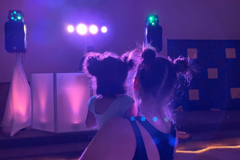 Iliana Hazzard holds her 20-month-old daughter Daphne while facing the DJ booth at a "Baby Rave" in Oakland