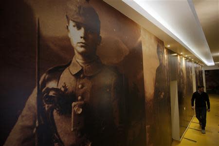 A worker walks near World War I portraits at the Franz Ferdinand hostel in Sarajevo, January 29, 2014. REUTERS/Dado Ruvic