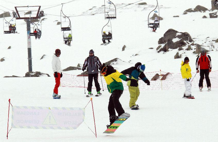 Snowboarders on the slopes, at the ski resort Porte Puymorens, in southwestern France, Saturday, June 1, 2013. The still-white slopes in the Pyrenees of southern France opened for business on Saturday, turning a cold damp spring into an rare June ski weekend. The Porte-Puymorens ski station opened Saturday morning at 8 a.m. for four hours in fog and light rain _ but plenty of snow with temperatures just above freezing. (AP Photo/Bob Edme)