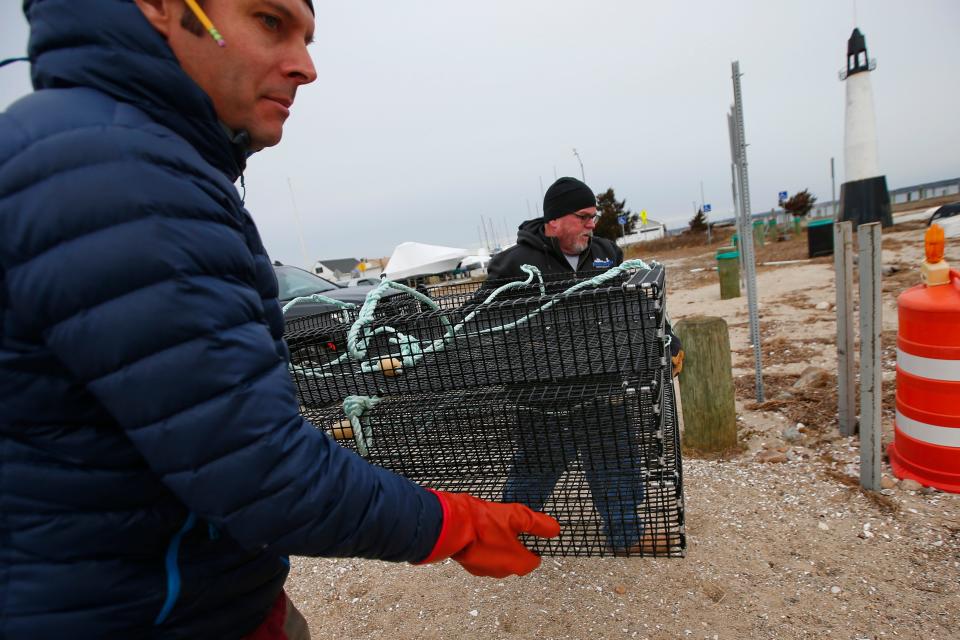 Timothy Cox, Fairhaven Shellfish Constable, right, and Steve Kirk, Coast Program Director for The Nature Conservancy, place oyster cages onto a boat tied up at Hoppys Landing in Fairhaven. Shellfish growers from Blue Stream Aquaculture in Fairhaven planted over 10,000 oysters in Nasketucket Bay on a one-acre oyster restoration site. The oysters are from two oyster farms in Fairhaven, both of which are participating in the second round of The Nature Conservancy and Pew Charitable Trust Supporting Oyster Aquaculture and Restoration (SOAR) program.