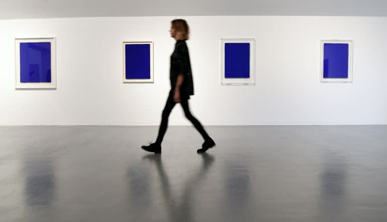 A curator walks past untitled works by French artist Yves Klein on display as part of the launch of the winter season at the Tate gallery in Liverpool, north west England on October 20, 2016