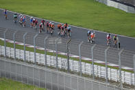 Athletes compete during the men's cycling road race at the 2020 Summer Olympics, Saturday, July 24, 2021, in Oyama, Japan. (AP Photo/Christophe Ena)