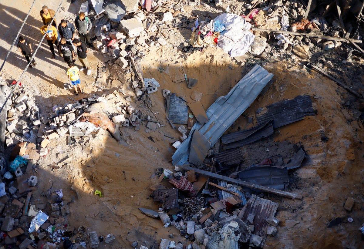 Palestinians inspect the site of an Israeli strike on a house in Rafah, in the southern Gaza Strip (REUTERS)