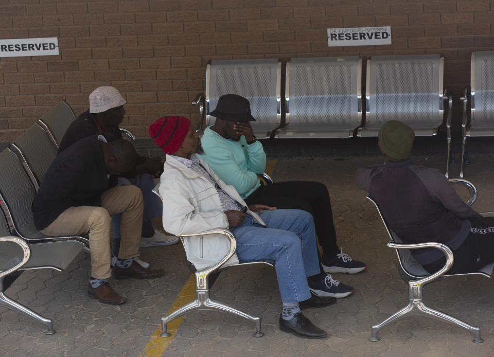 People wait at a forensic mortuary to identify bodies in Soweto, Johannesburg, South Africa, Friday, Sept. 1, 2023, after one of South Africa's deadliest inner-city fires as pathologists faced the grisly task Friday of identifying dozens of charred bodies and some separate body parts that had been transported to several mortuaries across the city of Johannesburg. (AP Photo/Denis Farrell)