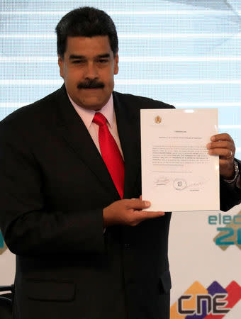 Venezuela's re-elected President Nicolas Maduro holds a certificate given by the National Electoral Council (CNE), confirming him as winner of Sunday's election, in Caracas, Venezuela May 22, 2018. REUTERS/Marco Bello