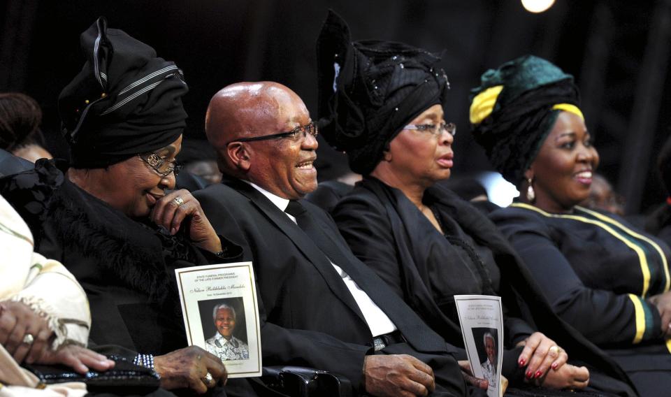 Winne Mandela (L), ex-wife of former South African President Nelson Mandela, and Graca Machel (2nd R), widow of Mandela, and South African President Jacob Zuma attend Mandela's funeral ceremony in Qunu, Eastern Cape in this December 15, 2013 handout picture provided by the South African Government Communication and Information System (GCIS). REUTERS/Kopano Tlape/GCIS/Handout via Reuters (SOUTH AFRICA - Tags: SOCIETY OBITUARY POLITICS) ATTENTION EDITORS - THIS IMAGE HAS BEEN SUPPLIED BY A THIRD PARTY. IT IS DISTRIBUTED, EXACTLY AS RECEIVED BY REUTERS, AS A SERVICE TO CLIENTS. FOR EDITORIAL USE ONLY. NOT FOR SALE FOR MARKETING OR ADVERTISING CAMPAIGNS. NO SALES. NO ARCHIVES