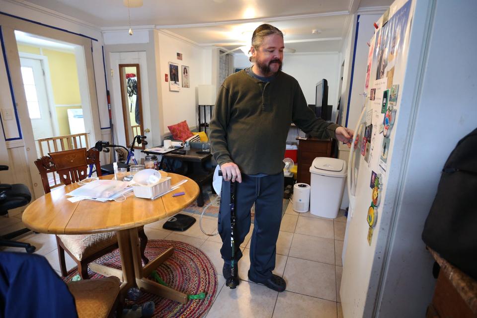 Benjamin Brighton, who is recovering from a rare spinal disorder, uses a cane to walk around his Somersworth home.