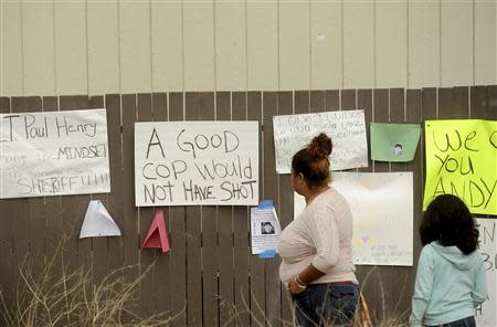 Signs hang in a vacant lot where 13-year-old Andy Lopez Cruz was shot and killed by sheriff's deputies on Tuesday in Santa Rosa, California October 27, 2013. REUTERS/Noah Berger