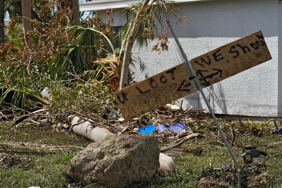 Residents placed a “you loot, we shoot” sign on their their flooded property Tuesday, Oct. 4, 2022, in North Port, Fla. Residents in the area continue cleaning up after Hurricane Ian came ashore along Florida’s west coast last week. (AP Photo/Chris O’Meara)