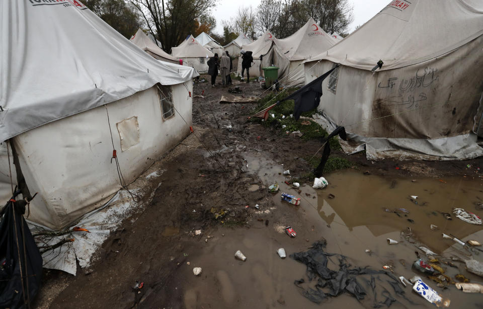 Migrants walk in the Vucjak refugee camp outside Bihac, northwestern Bosnia, Thursday, Nov. 14, 2019. The European Union's top migration official is warning Bosnian authorities of a likely humanitarian crisis this winter due to appalling conditions in overcrowded migrant camps in the country. (AP Photo/Darko Vojinovic)