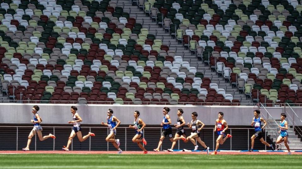 Atletas corriendo por un estadio.