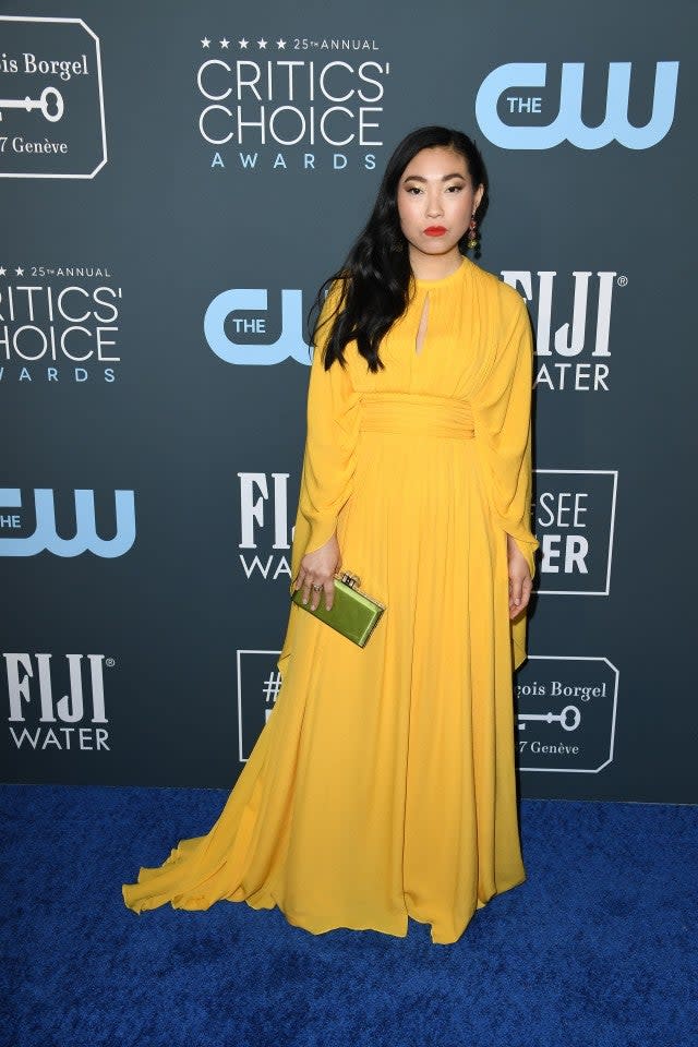 'The Farewell' actress brightened up the red carpet in a stunning marigold pleated dress at the Critics' Choice Awards.