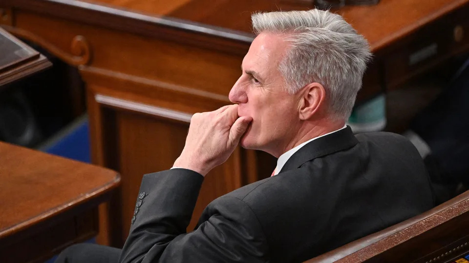Rep. Kevin McCarthy, seated on a wooden bench, wears a worried expression.