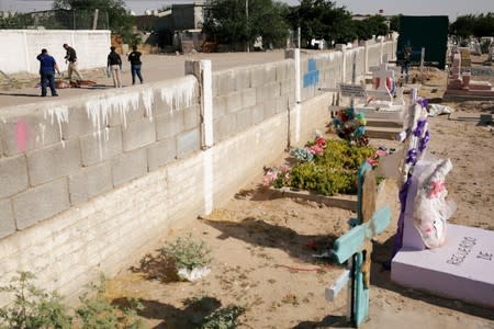 Forensic technicians work at a crime scene where unknown assailants left a headless body wrapped in blankets, in Ciudad Juarez