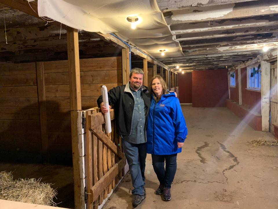 Jeremy Lees holds up blueprints with wife Melissa at the future home of Flounder Brewing.