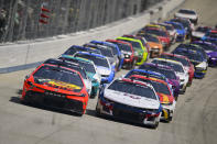 Martin Truex Jr. and William Byron lead the field into Turn 1 on a restart during a NASCAR Cup Series auto race at Dover Motor Speedway, Sunday, April 28, 2024, in Dover, Del. (AP Photo/Derik Hamilton)