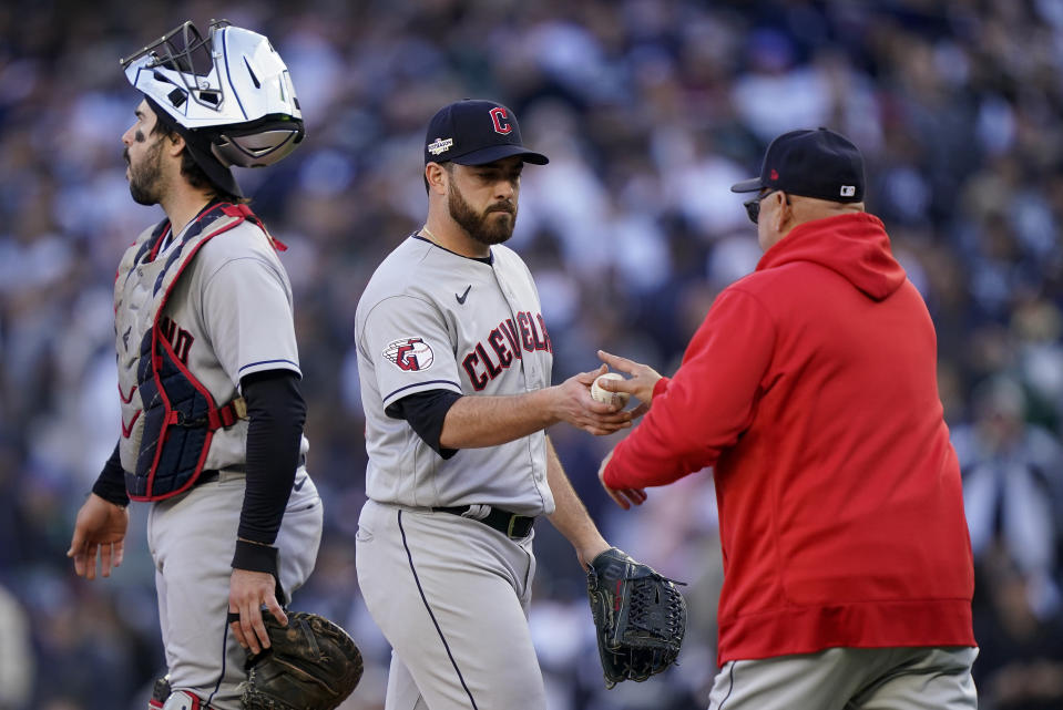 Cleveland Guardians pitcher Aaron Civale, center, hands the ball to manager Terry Francona as he leaves the game after giving up a three-run home run to the New York Yankees during the first inning of Game 5 of an American League Division baseball series, Tuesday, Oct. 18, 2022, in New York. (AP Photo/John Minchillo)